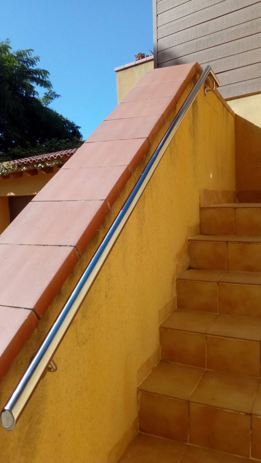 Una escalera con una barandilla de metal a un lado.