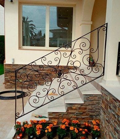Hay una barandilla de hierro forjado en las escaleras de una casa.