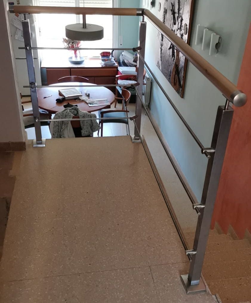 Una escalera que conduce a un comedor con una mesa y sillas.