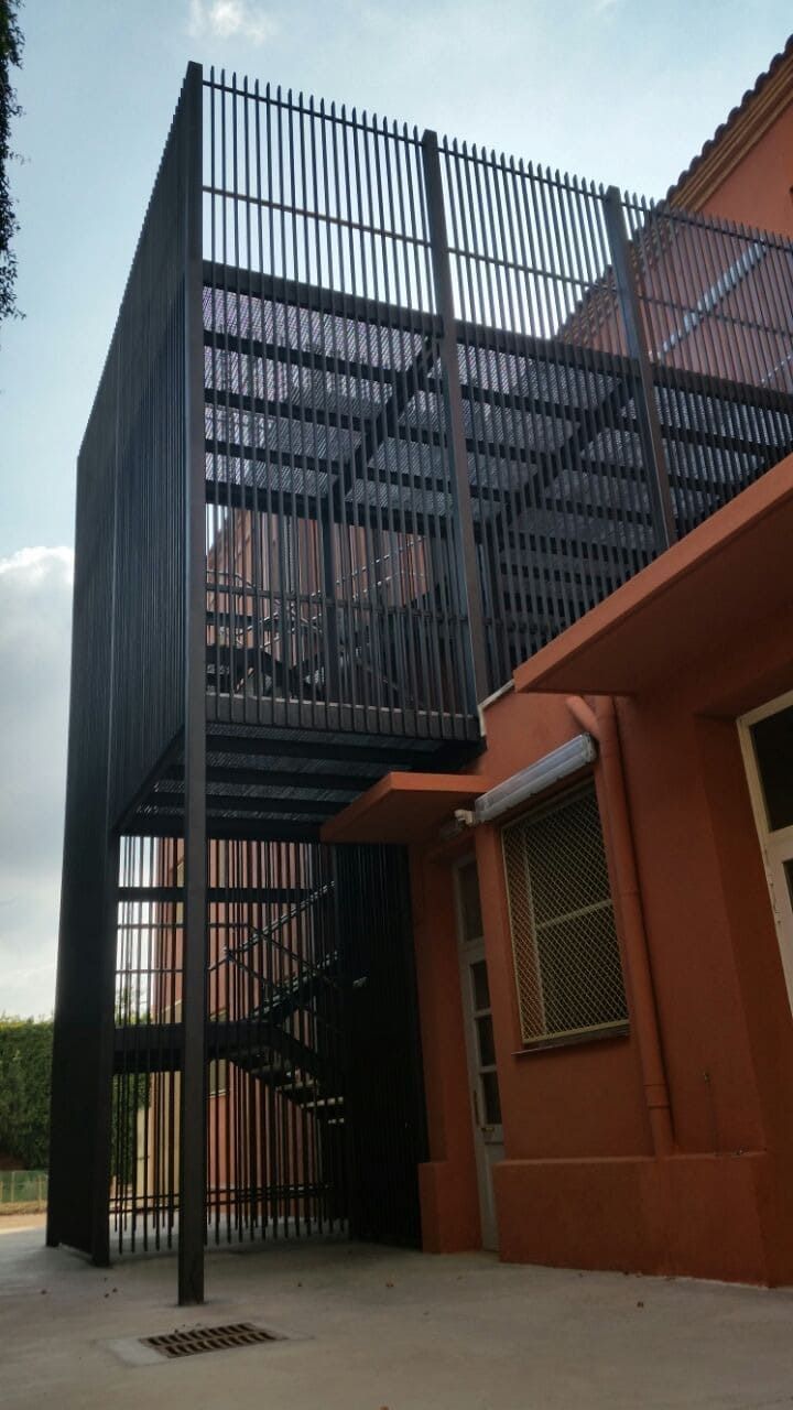 Un edificio con una escalera al costado.