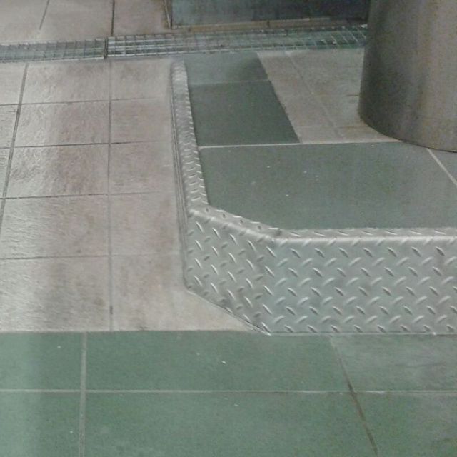 Una escalera de metal con un patrón de diamantes.