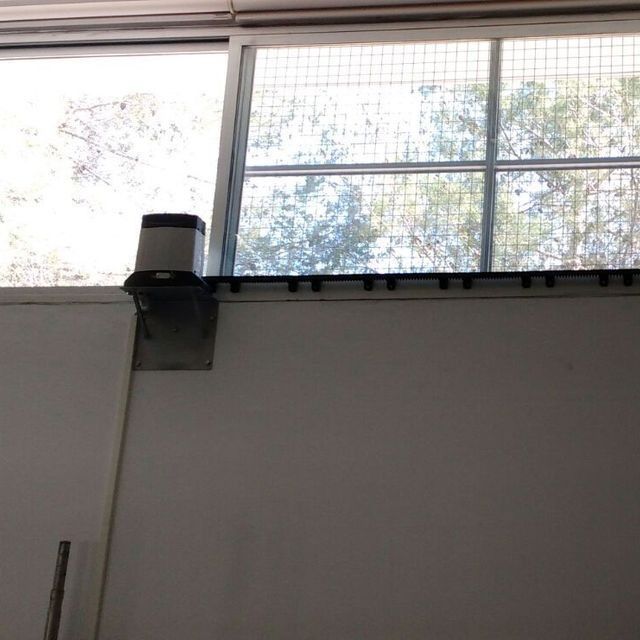 Una pared blanca con una gran ventana detrás.