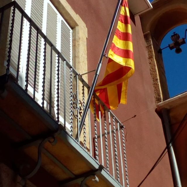 Una bandera roja y amarilla ondea desde un balcón