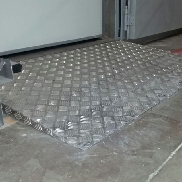 Una rampa de metal está en el suelo al lado de una puerta.