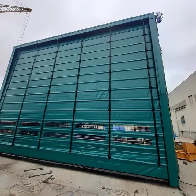 Un gran edificio verde con una grúa al fondo.