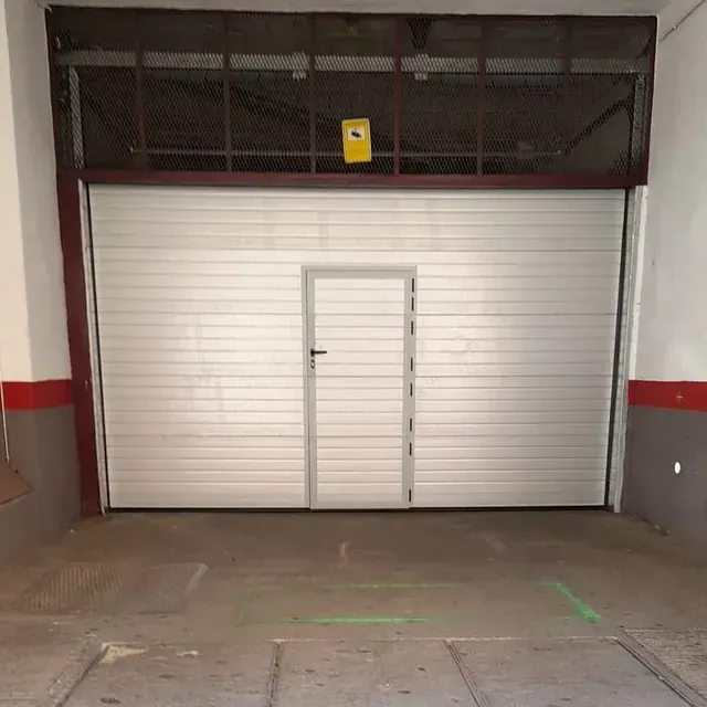 Una puerta de garaje blanca con una puerta dentro.