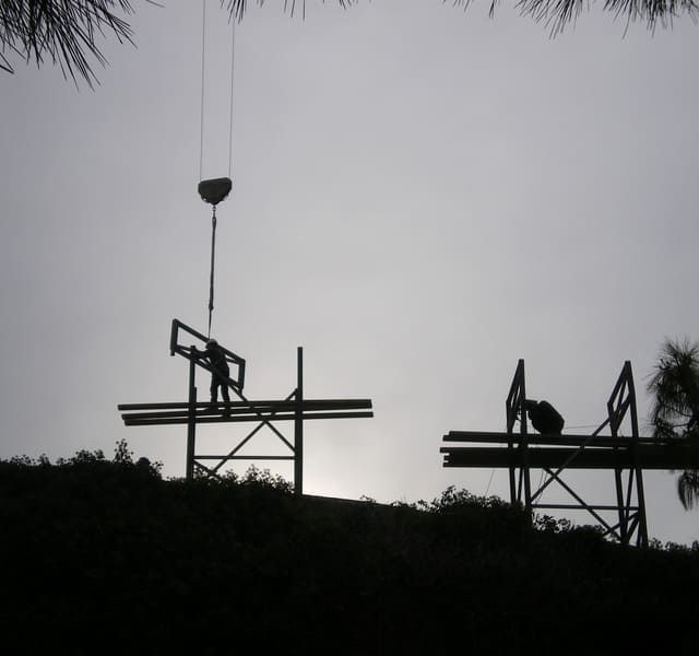 Una silueta de un sitio de construcción con una grúa al fondo.