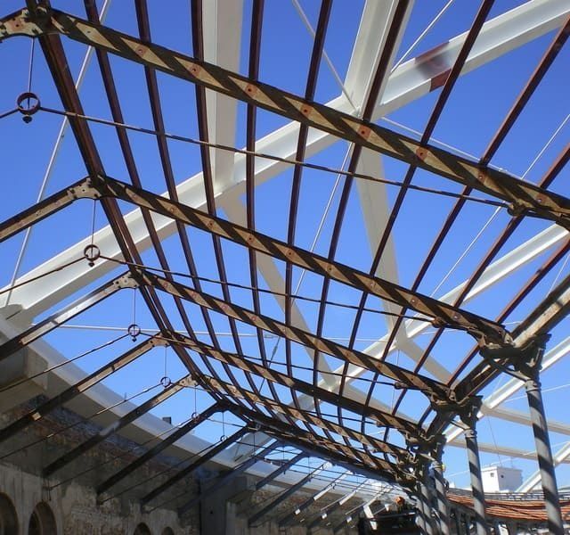 Mirando hacia el techo de un edificio con un cielo azul de fondo