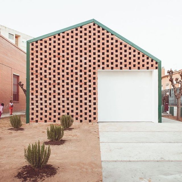Un edificio de ladrillo con una puerta blanca y un marco verde.
