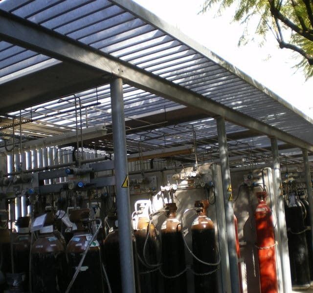 Una fila de cilindros de gas están alineados bajo un dosel