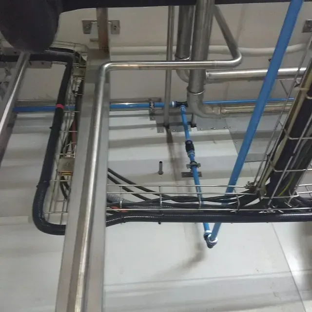 Un montón de tubos y cables colgando del techo