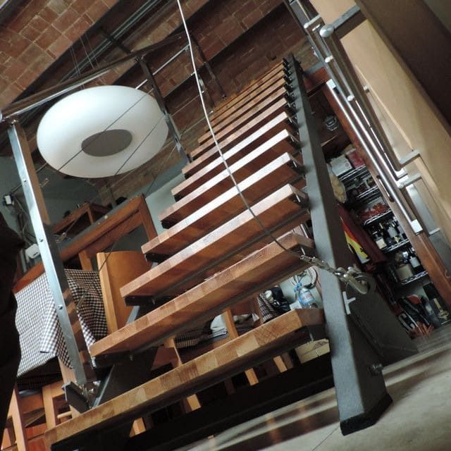 Una escalera de madera con una luz blanca colgando del techo.