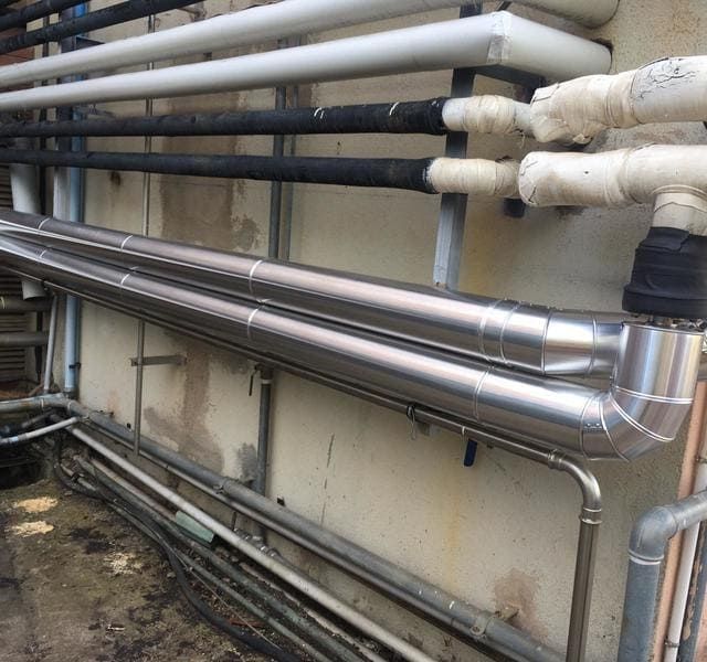 Un montón de tubos están alineados contra una pared