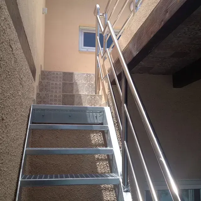 Un conjunto de escaleras metálicas con barandilla de acero inoxidable.