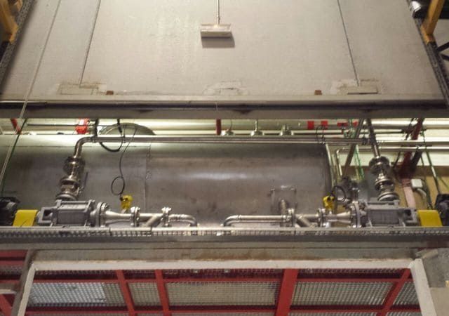 Un gran contenedor de metal del que salen muchos tubos.