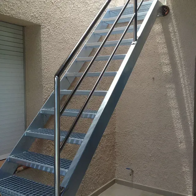 Un conjunto de escaleras metálicas con barandilla metálica.