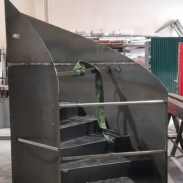 Se está construyendo una escalera de metal en una fábrica.
