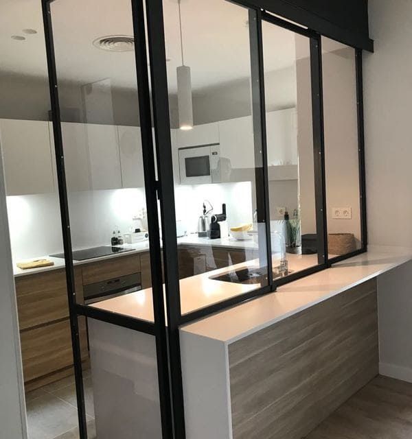 Una cocina con una puerta corrediza de vidrio entre la cocina y la sala de estar.