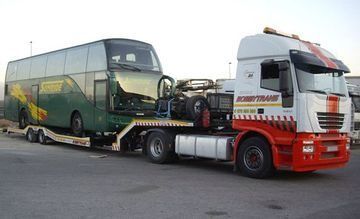 Un autobús de dos pisos está siendo remolcado por un camión semirremolque
