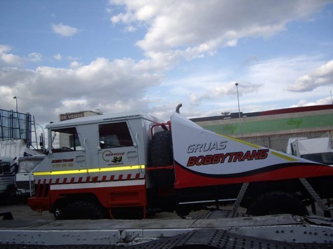 Un camión de la grúa Bobbytrans está estacionado en un estacionamiento.