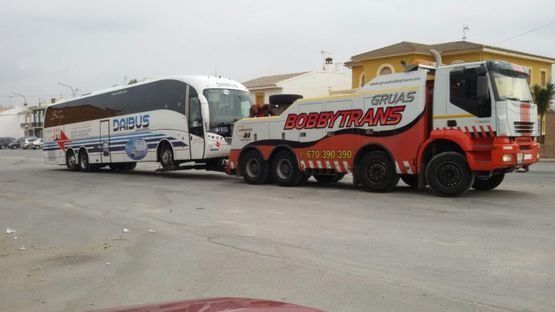 Un autobús está siendo remolcado por una grúa.