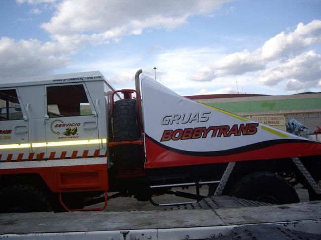 Un camión rojo y blanco que dice gruas bobbytrans