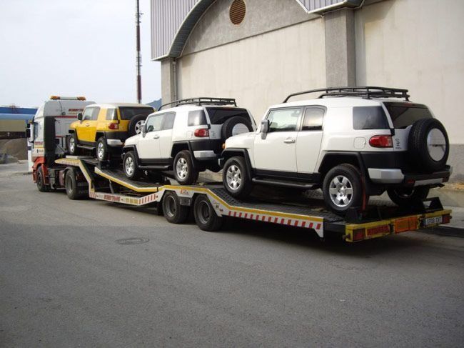 Una fila de coches se transportan en un remolque