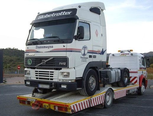 Un camión semirremolque Volvo con un remolque de plataforma acoplado.