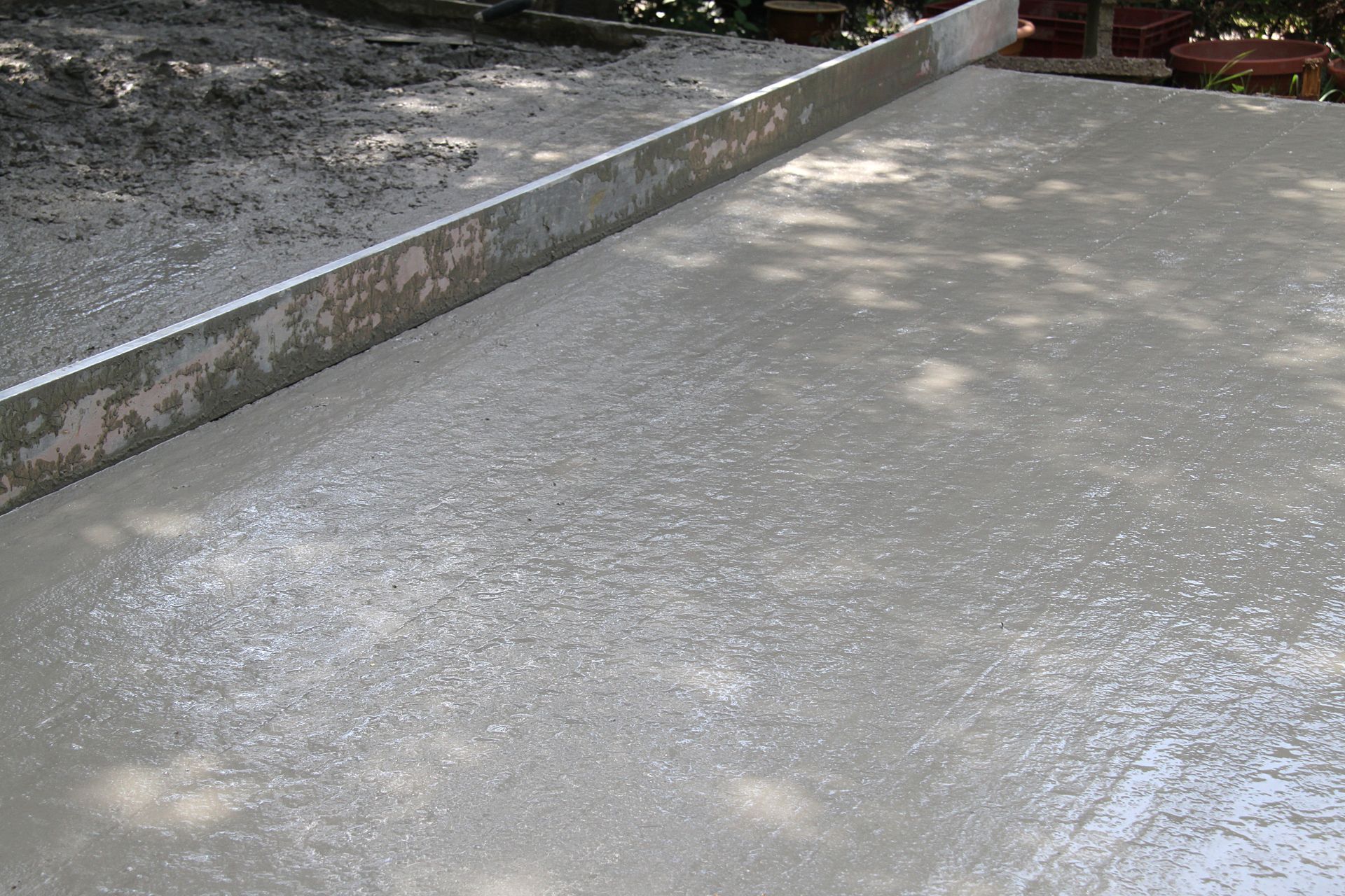 Surface de béton fraîchement coulée avec un outil à chape.