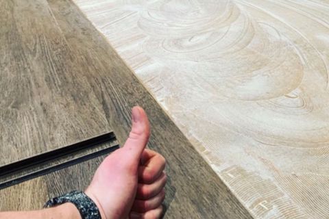 Mann verlegt Holzfußboden in einem Zimmer