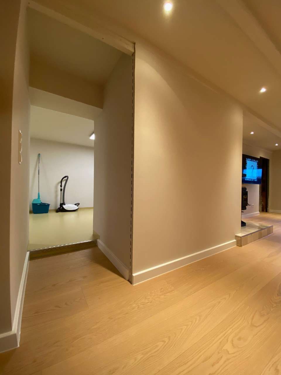 Leerer Flur mit hell-beige gestrichenen Wänden und Holzfußboden