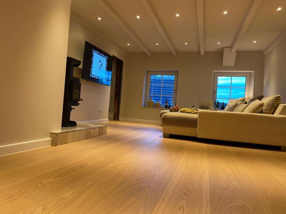 Wohnzimmer mit Holzfußboden und Ambiente-Beleuchtung