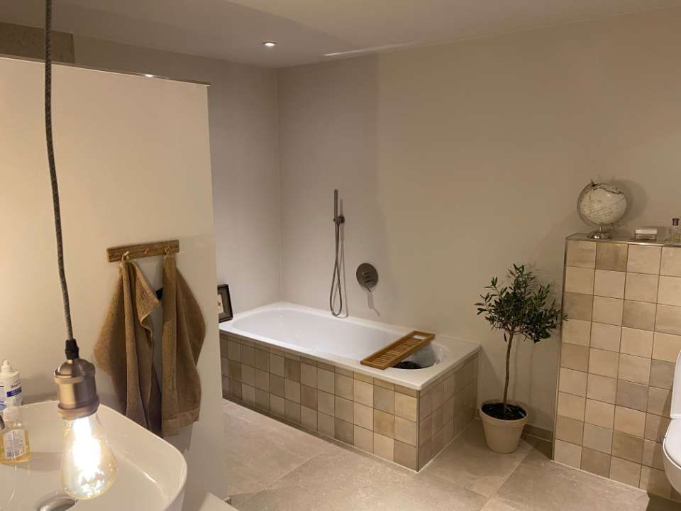 Leerer Flur mit hell-beige gestrichenen Wänden und Holzfußboden