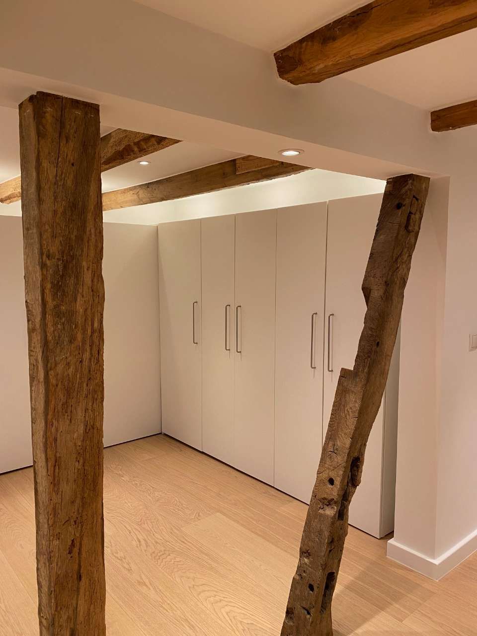 Holzfußboden in einem Raum mit Balken und Säulen aus Holz