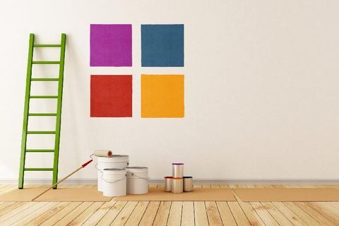 Grüne Leiter vor weißer Wand mit vier bunten aufgemalten Quadraten