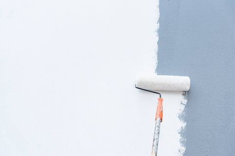 Leiter vor gelber nicht fertig gestrichener Wand