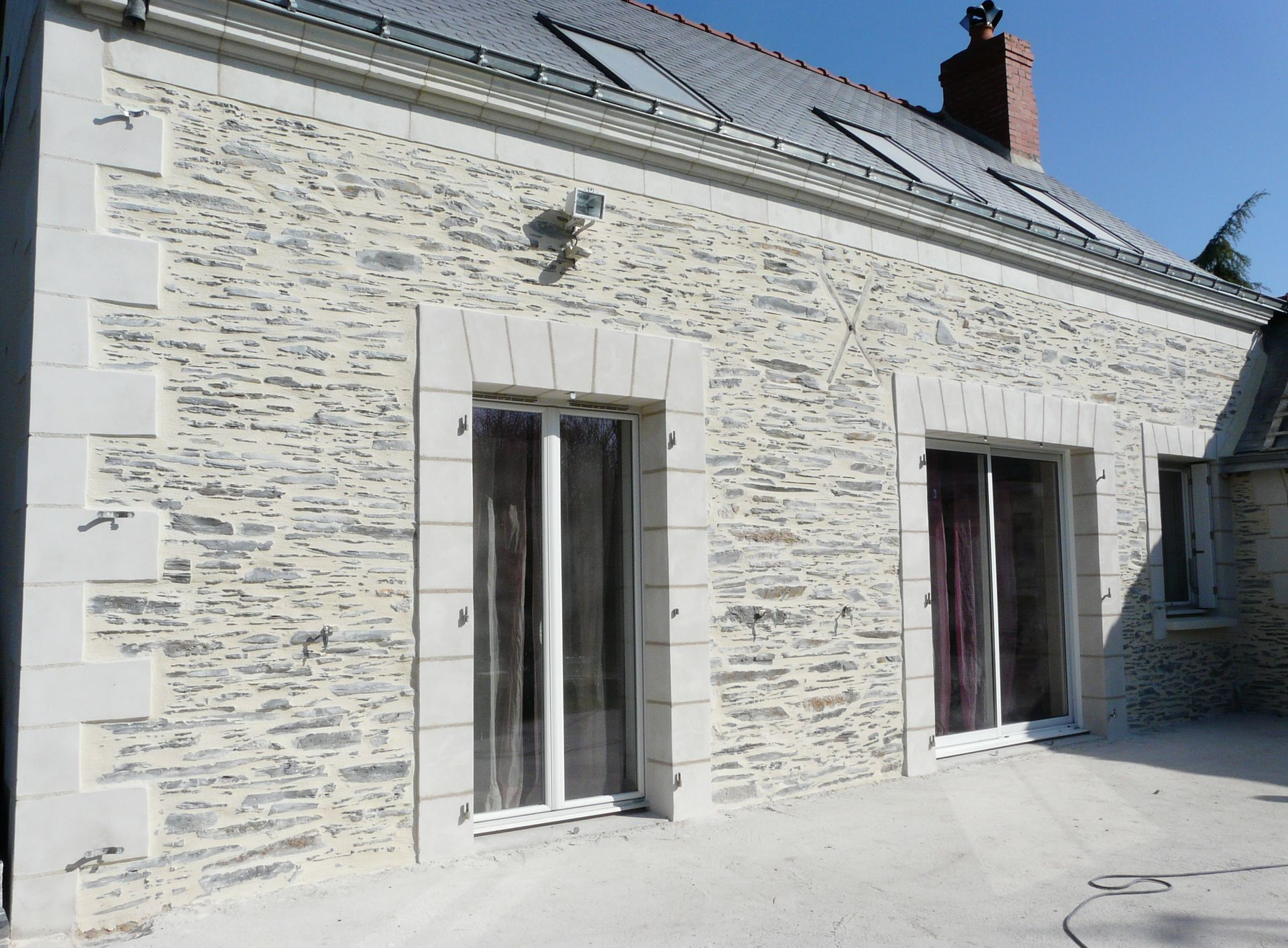 Façade de maison après un ravalement de façade en ardoise et imitation en tuffeau autour des menuiseries extérieures