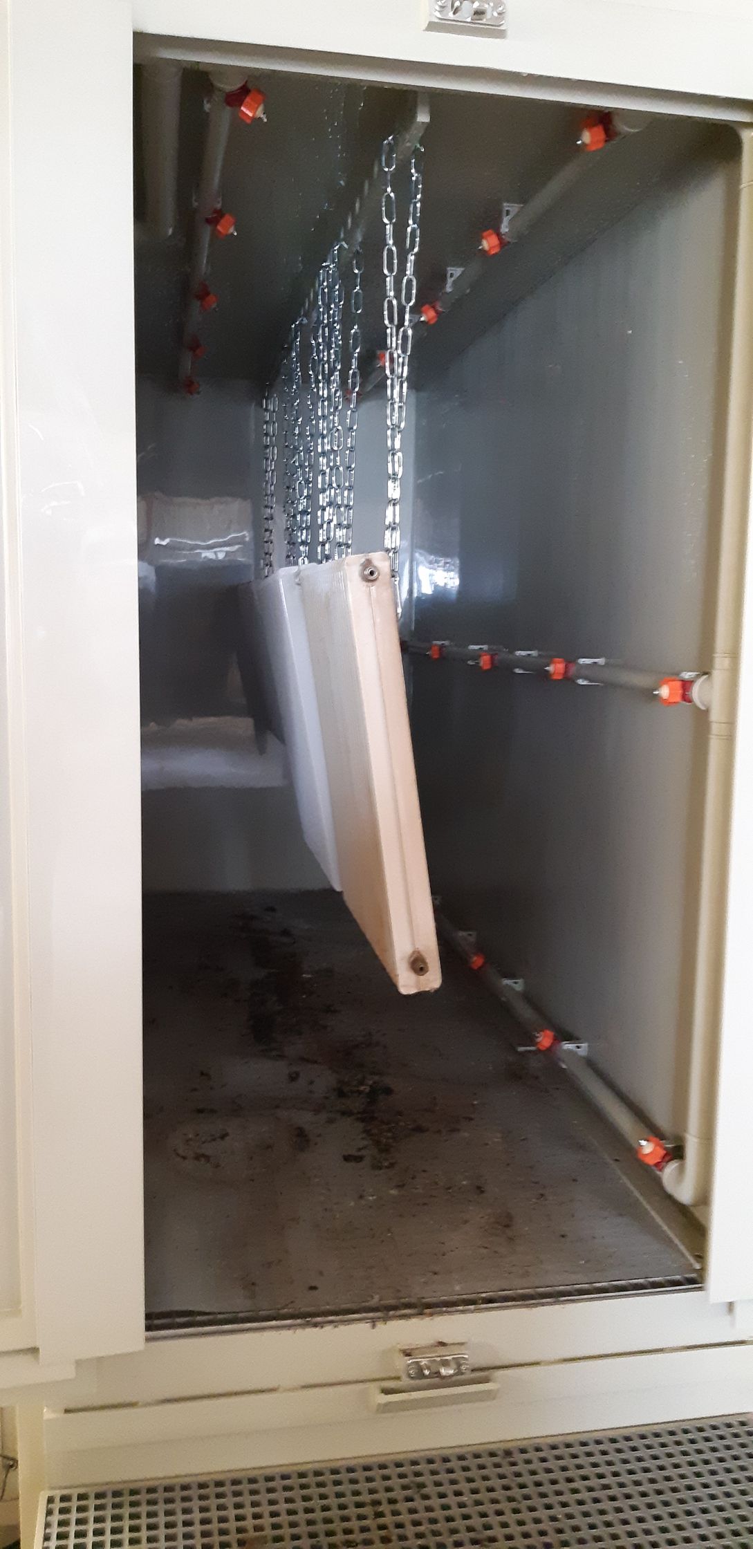 Travaux de décapage par aérogommage sur des radiateurs suspendus par des chaînes métalliques