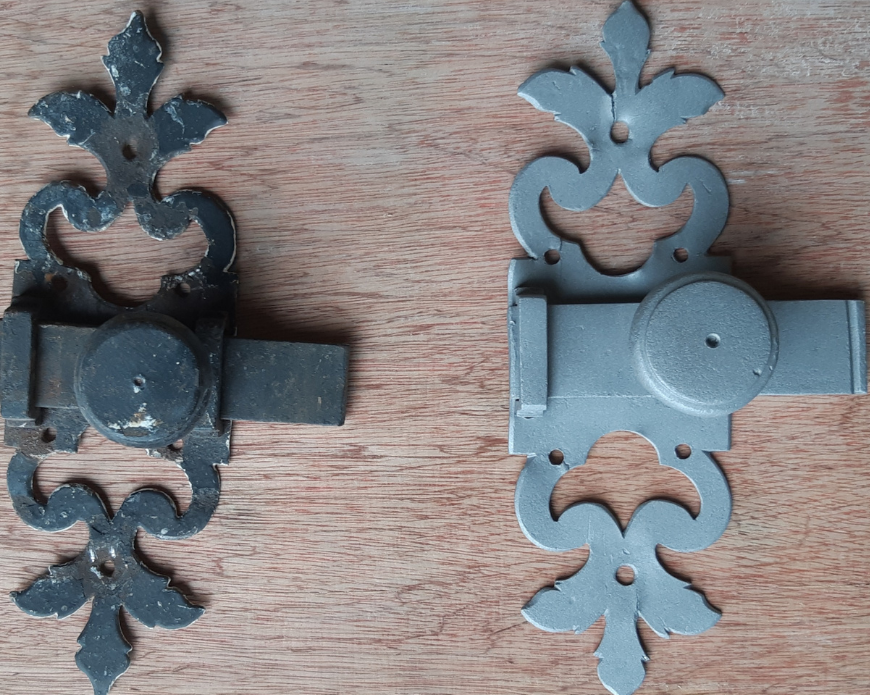 Deux charnières métalliques ornementées, l'une noire et l'autre grise, montées sur une surface en bois.
