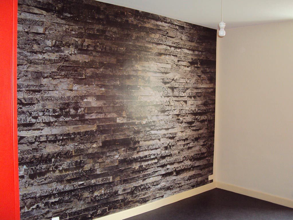 Pièce vide avec un mur d'accent texturé foncé, des murs beiges et une moquette beige clair.