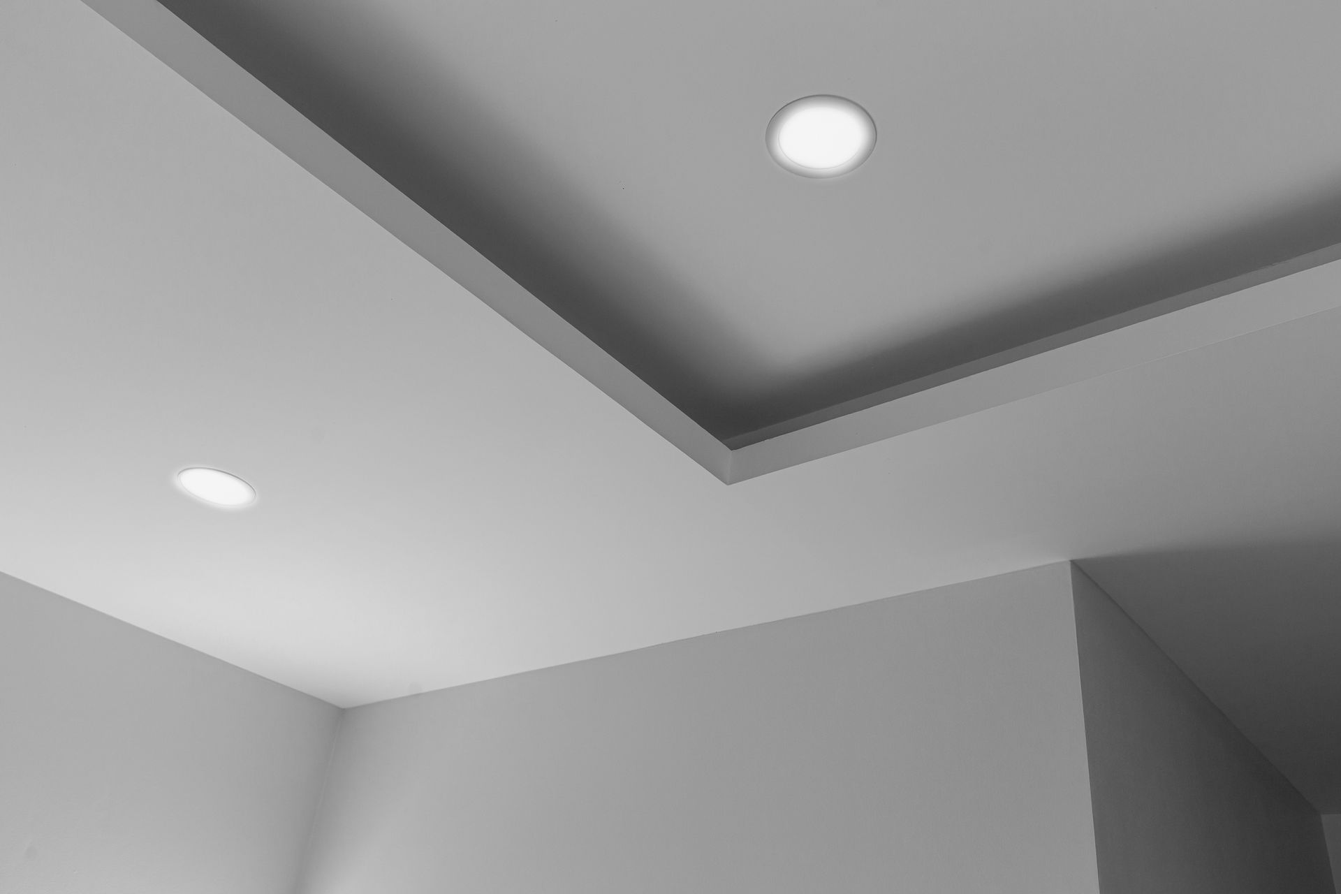 Coin de plafond avec éclairage encastré dans une pièce moderne grise.