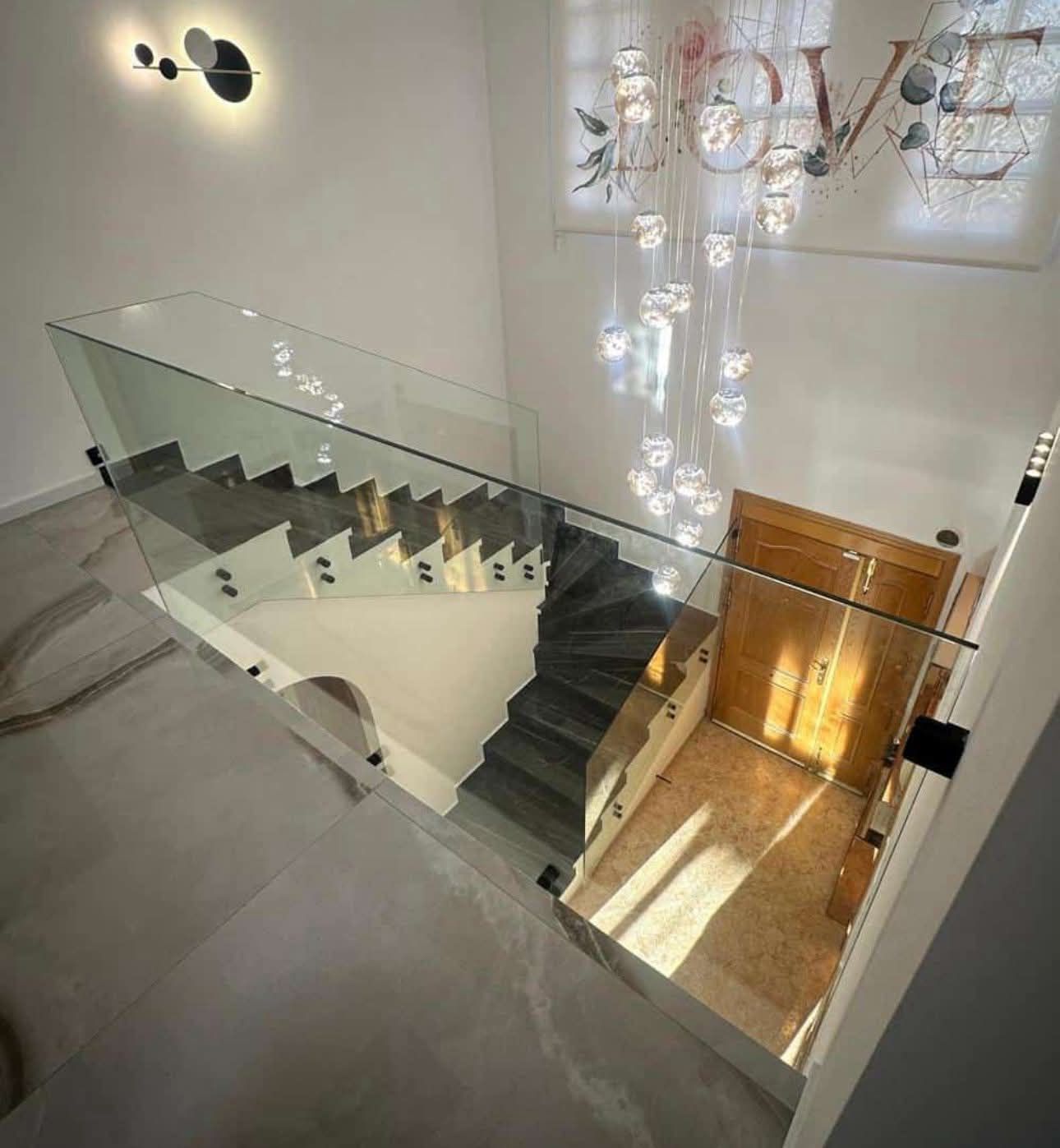 Una escalera moderna con barandilla de cristal.