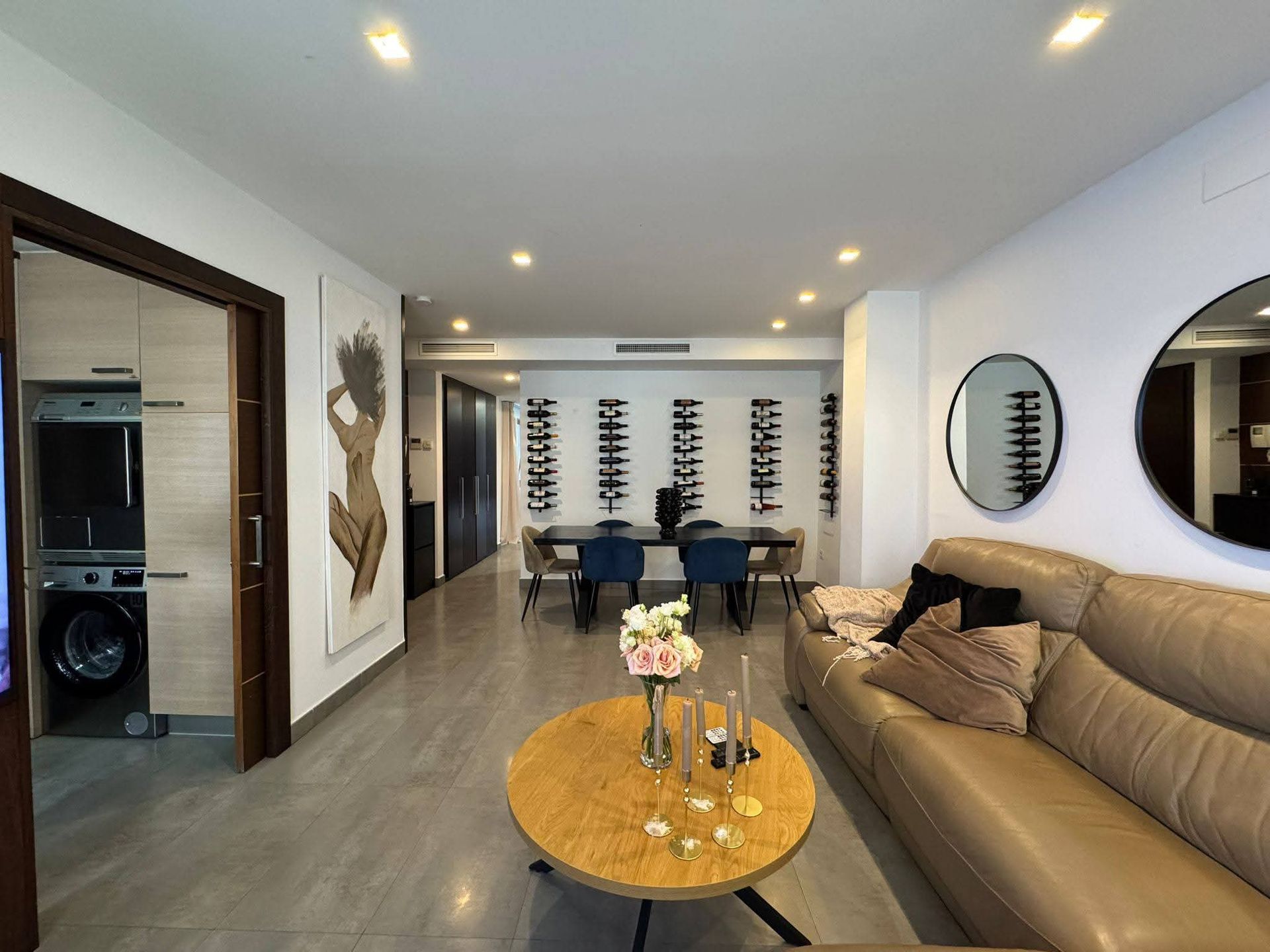 Moderna sala de estar con sofá de cuero, comedor y bodega de vinos.