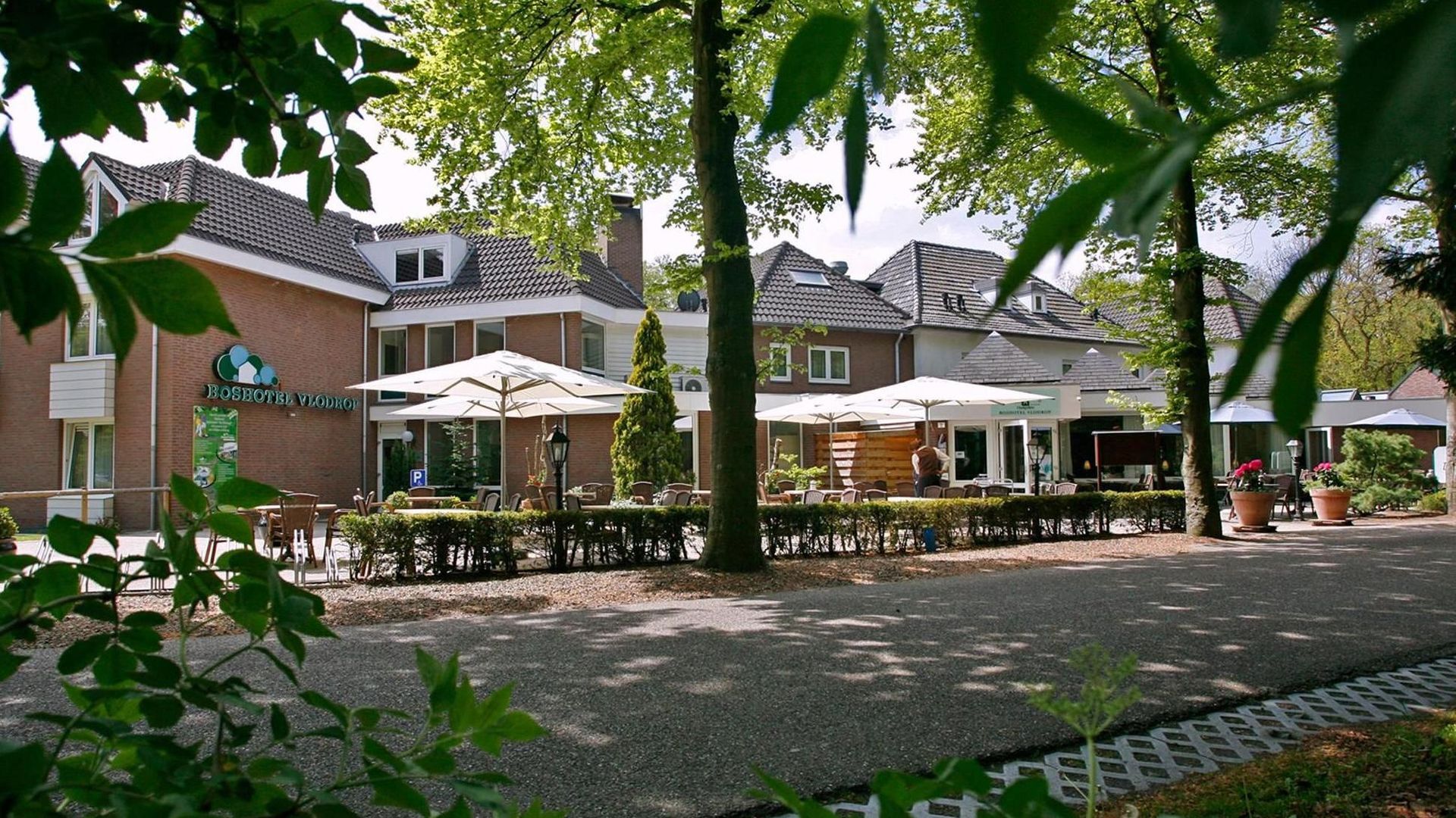 Ein großes Haus mit vielen Sonnenschirmen auf der Terrasse