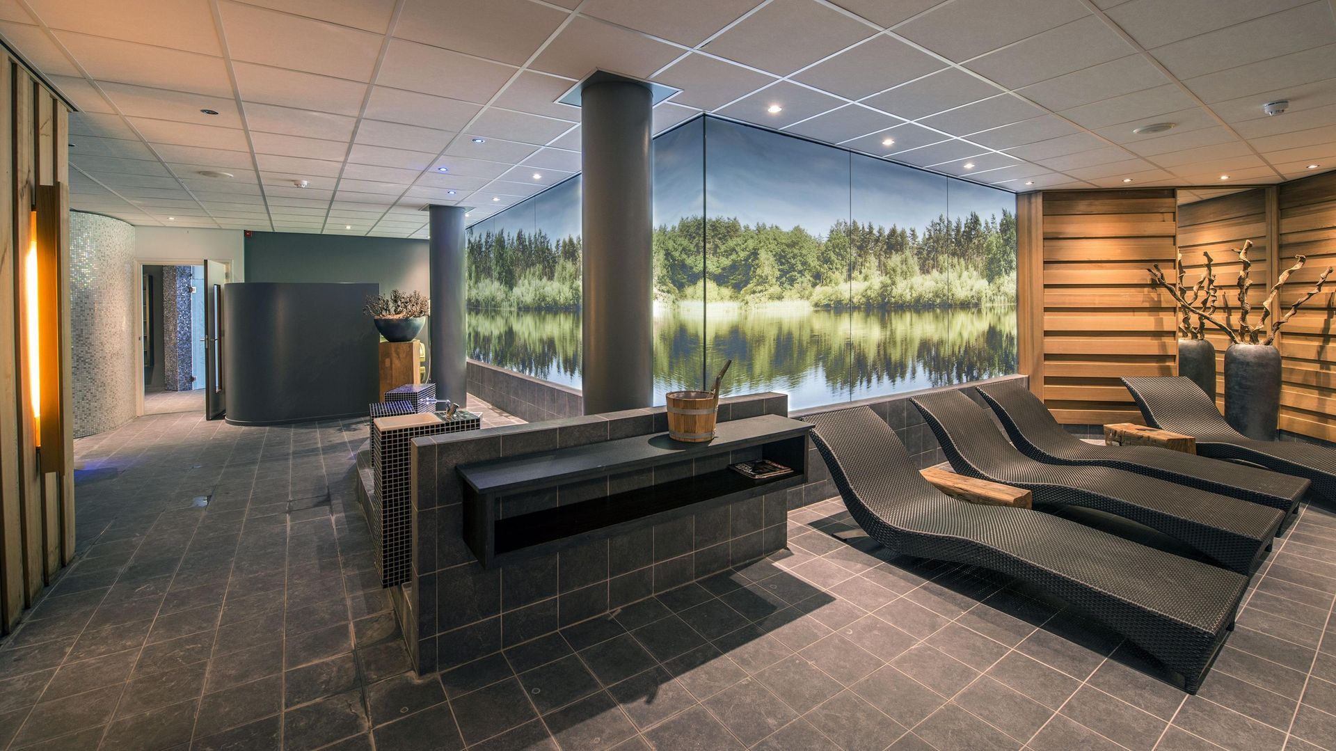 Ein großer Raum mit vielen Stühlen und einem Bild von einem See an der Wand.