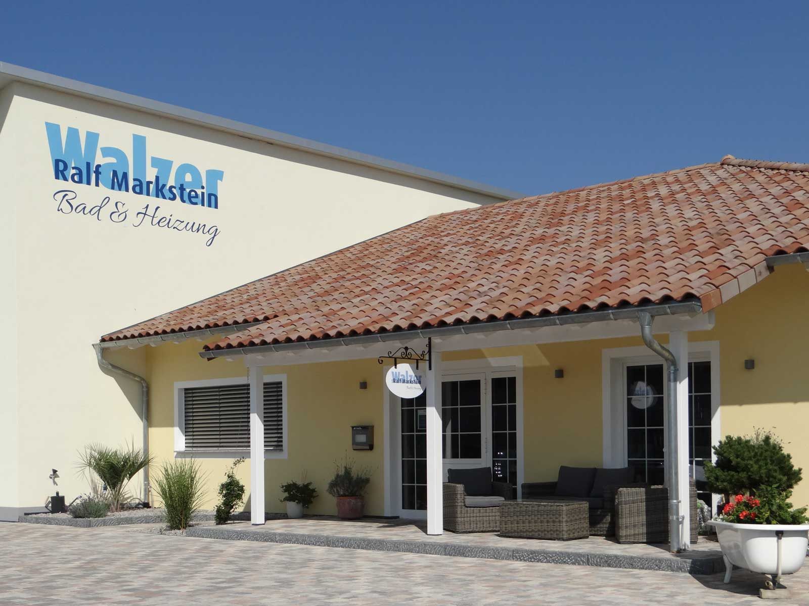 Ralphs-Marktfassade mit beigen Wänden, rotem Ziegeldach und überdachtem Eingang