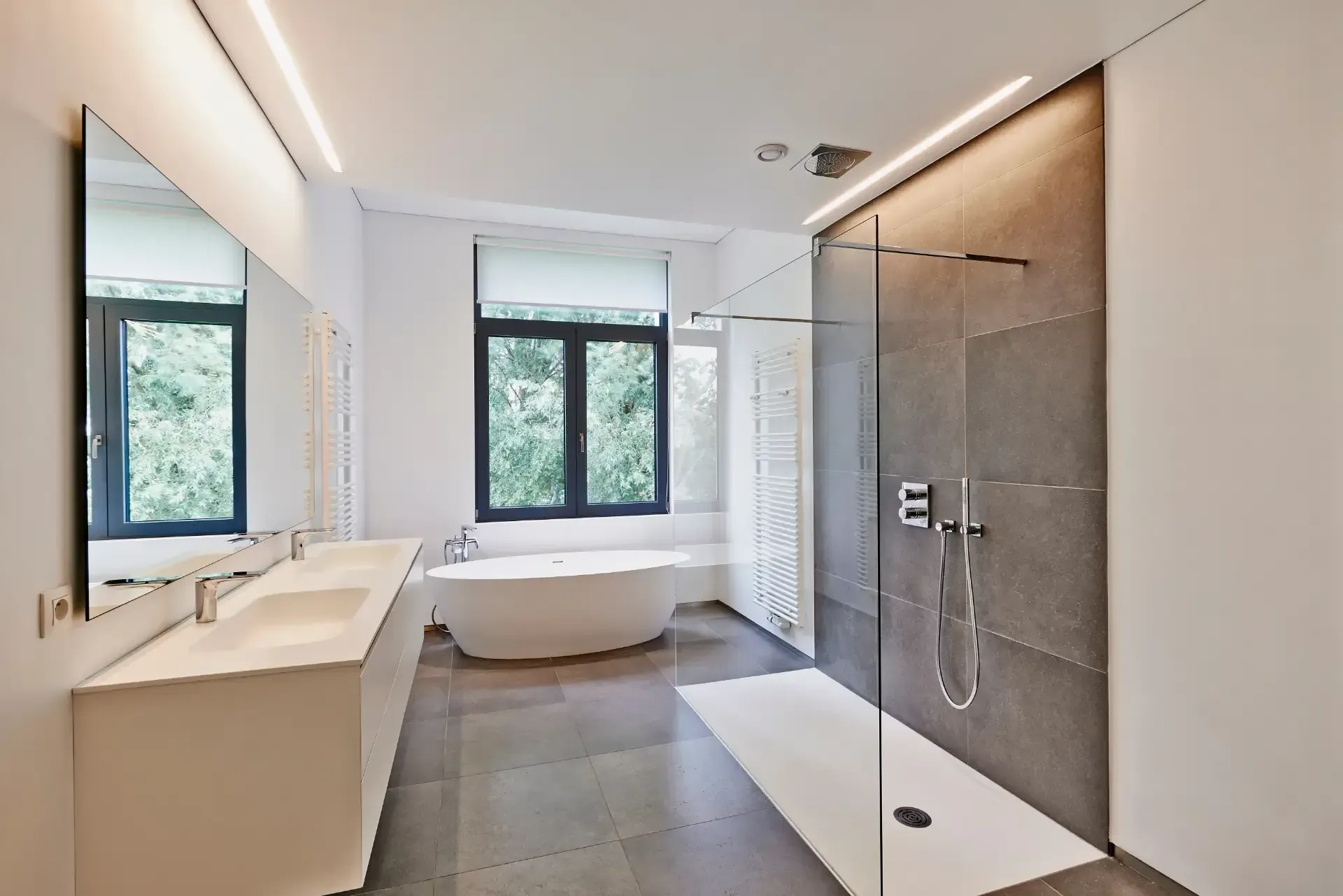 Modernes Badezimmer mit ebenerdiger Dusche, freistehender Badewanne, Doppelwaschbecken und großen Fenstern
