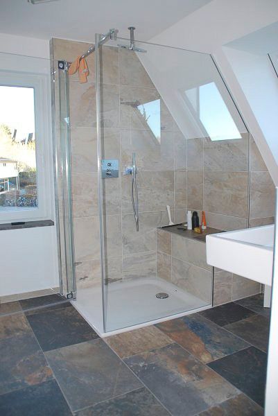 Modernes Badezimmer mit ebenerdiger Glasdusche, beige gefliesten Wänden und Schieferbodenfliesen.