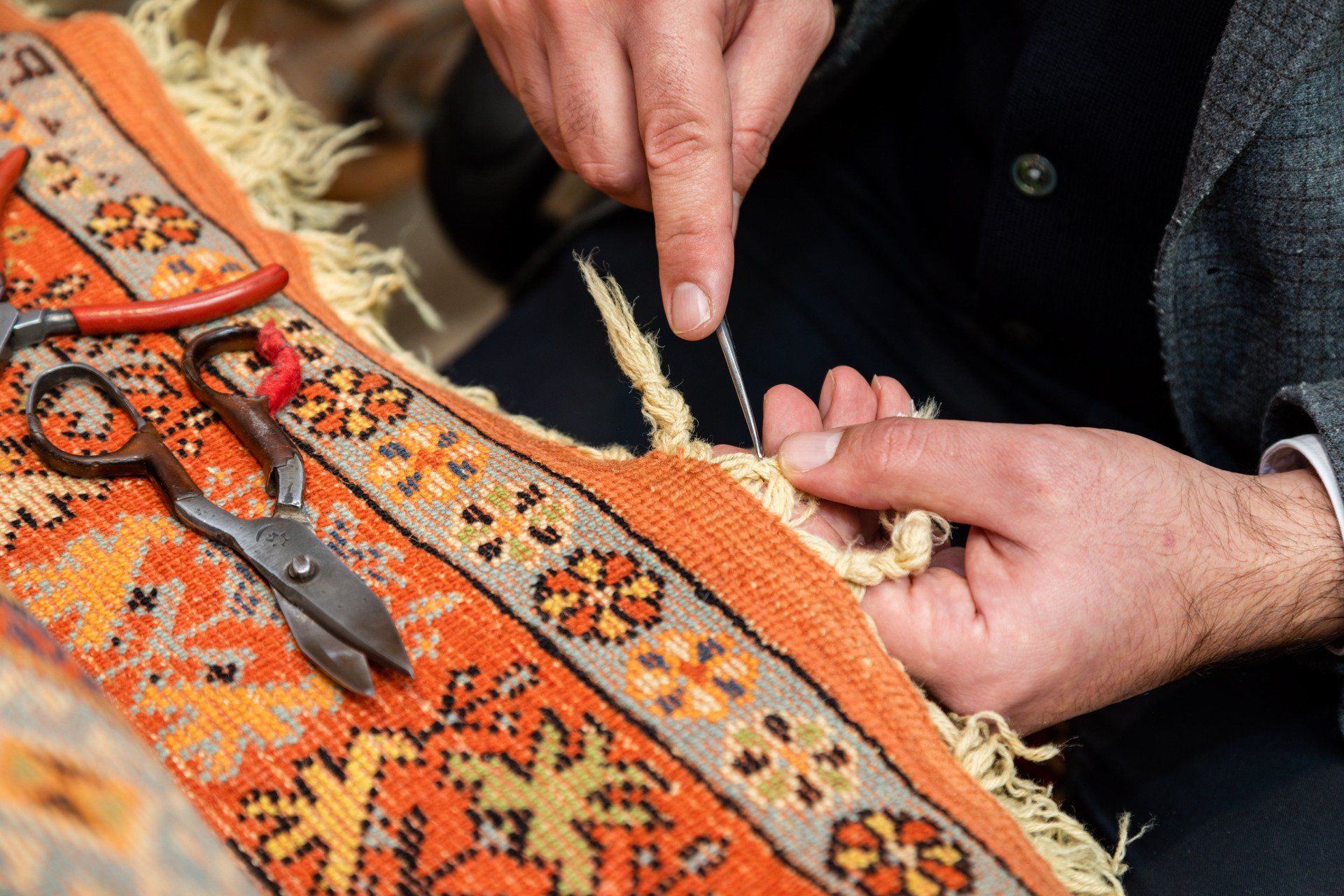 Tapis orange en cours de restauration de sa frange