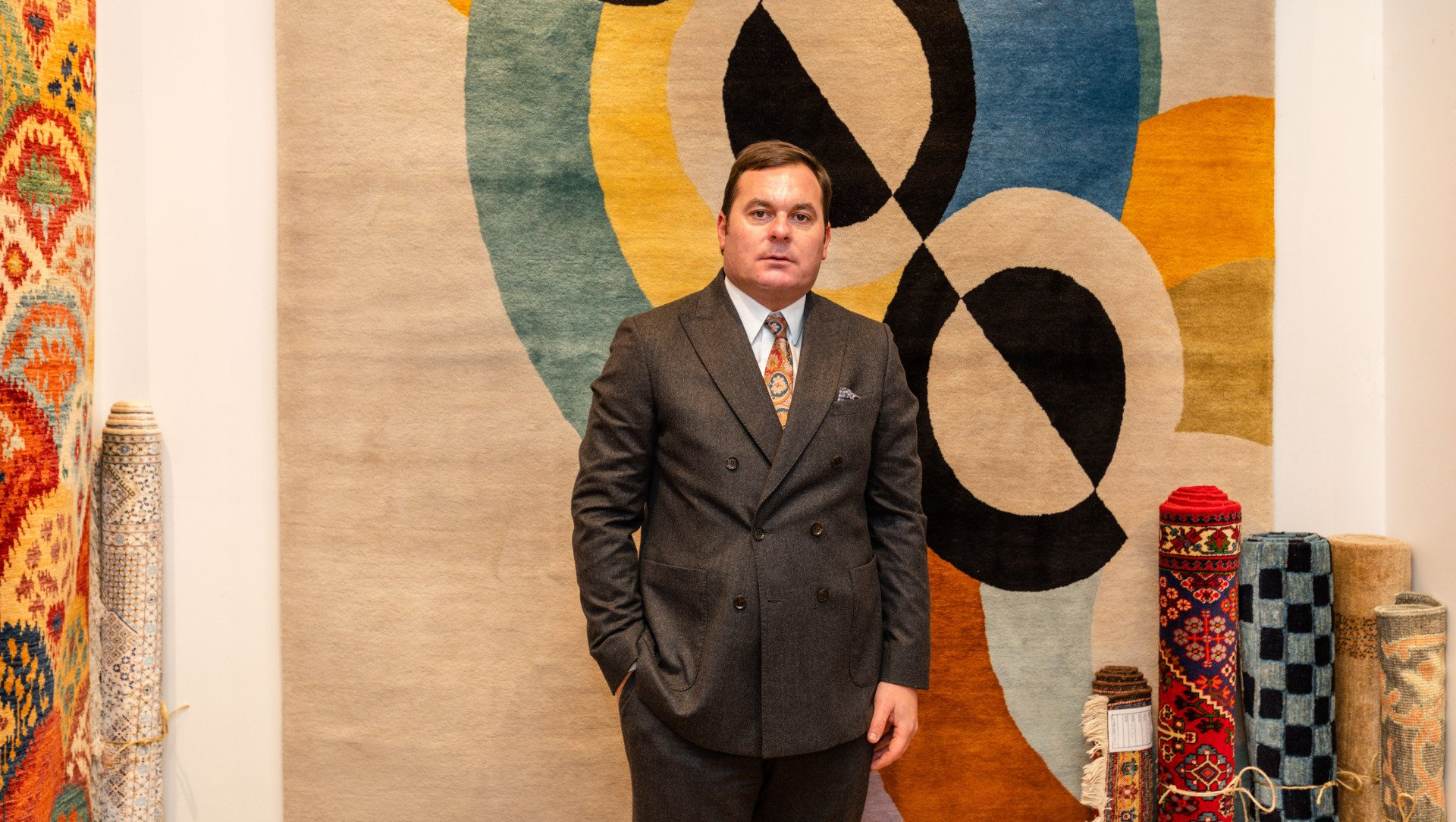 Alexandre Lorot, homme en costard posant derrière un grand tapis